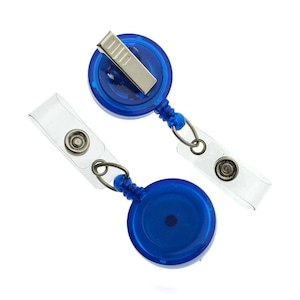 May include: Two blue retractable badge holders with clear plastic straps and metal clips. The badge reels are round and have a shiny, transparent appearance. The metal clips are silver and the plastic straps have a snap closure.