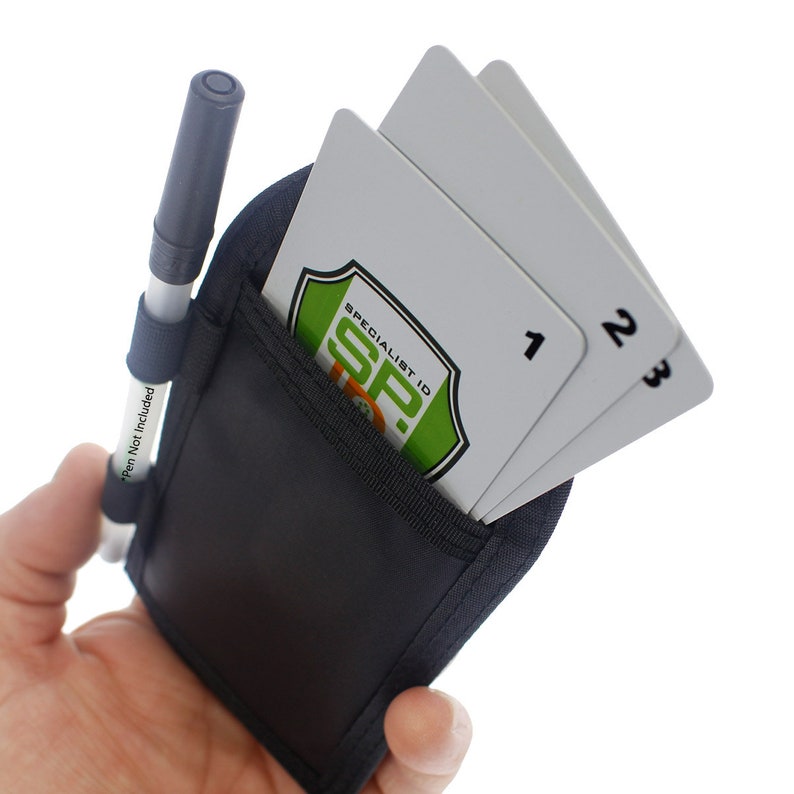 May include: A black pouch with a zippered pocket and a pen holder. The pouch has two white cards inside with the numbers 1, 2, and 3 printed on them. The pouch also has a green and orange logo that says "Specialist ID SP."