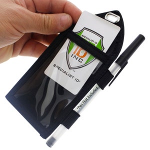 May include: Black ID badge holder with a clear plastic window for displaying an ID card. The holder has a strap for attaching a pen, and a loop for attaching a lanyard. The text "SPECIALIST ID" is printed on the ID card.