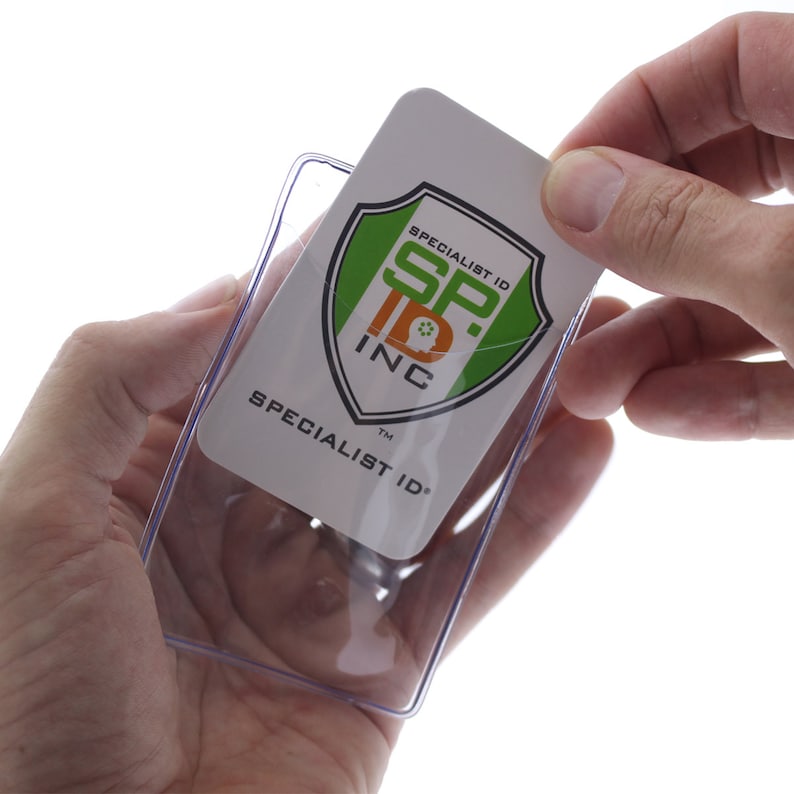 May include: Clear plastic badge holder with a white card inside. The card has a green and black logo with the text "Specialist ID SP. INC" and "Specialist ID" in black.