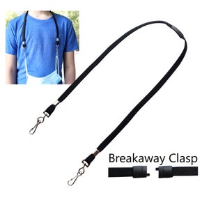 May include: Black lanyard with metal swivel hooks and a breakaway clasp. The lanyard is shown with a face mask attached. The text "Breakaway Clasp" is visible in the image.