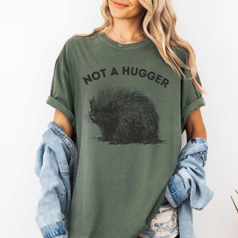 May include: A green t-shirt with a black and white illustration of a porcupine and the text "Not a Hugger".