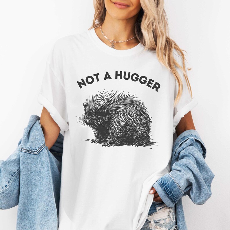 May include: White t-shirt with a black and white illustration of a porcupine and the text "Not a hugger".