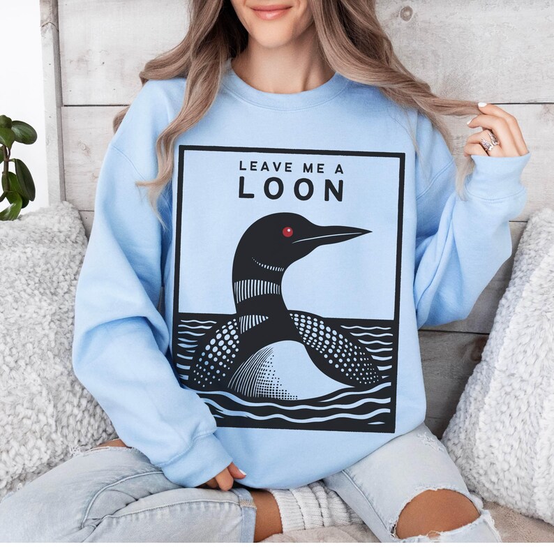 May include: Light blue sweatshirt with a graphic of a loon and the text "Leave me a loon".