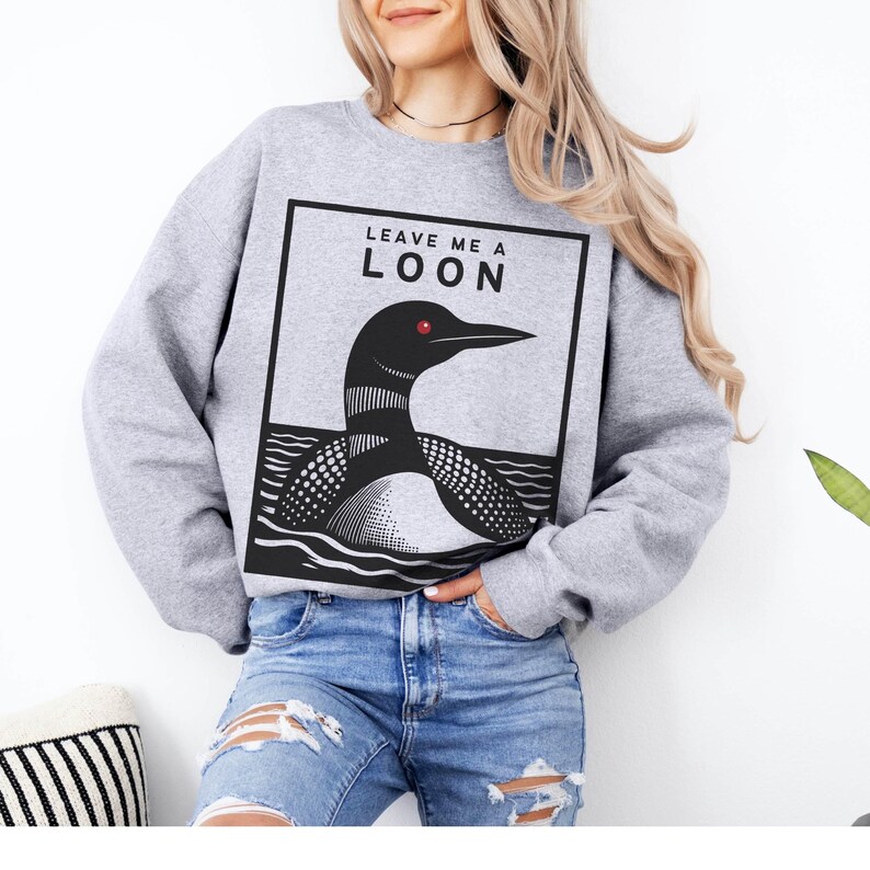 May include: Gray sweatshirt with a black and white illustration of a loon and the text "Leave Me A Loon".