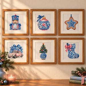 May include: Six square wooden frames containing cross-stitch patterns of holiday motifs: a nutcracker, a patterned ornament, a star cookie, a pink car with gifts, a small Christmas tree in a blue vase, and a blue stocking with a pink bow.