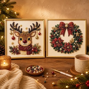 May include: Two square framed diamond art pieces featuring holiday themes. The left frame displays a reindeer with antlers adorned with ornaments and a red scarf. The right frame shows a Christmas wreath with red poinsettias and a large red bow.