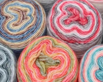 May include: Close-up of colorful yarn balls in various shades of blue, red, green, and yellow. The yarn is wound into balls and arranged in a circular pattern.