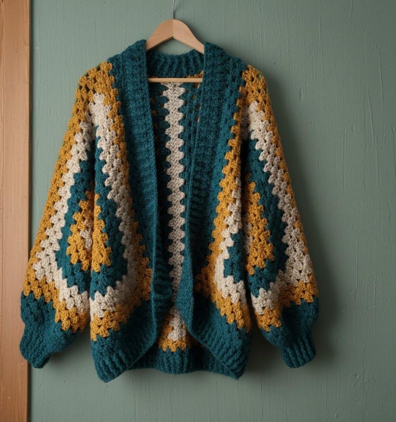 May include: A crochet cardigan featuring a granny square pattern in teal, mustard yellow, and cream. The garment has long sleeves with ribbed cuffs, a wide ribbed collar, and an open front design, constructed with thick yarn in a textured stitch.