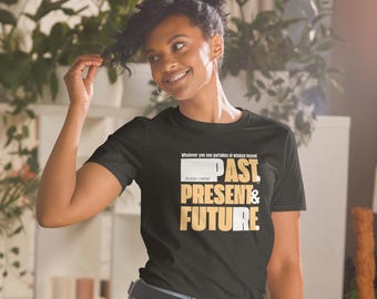 May include: Black t-shirt with the words "PAST, PRESENT & FUTURE" in white and gold lettering. The shirt also has the text "Whatever you see partakes of wisdom beyond" and the company name "ZEN REBEL COMPANY".