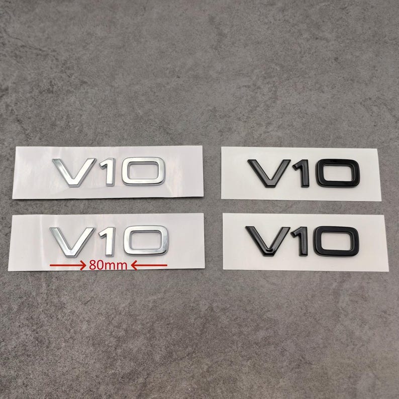 Puede incluir: Cuatro pegatinas de emblema de coche V10, dos en plata y dos en negro. Los emblemas plateados miden 80 mm de ancho. Las pegatinas est&aacute;n sobre papel blanco, listas para su aplicaci&oacute;n.