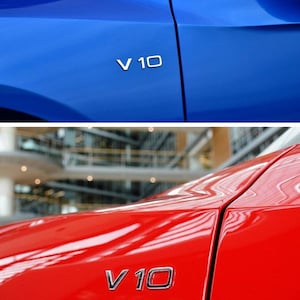 Puede incluir: Primer plano de dos paneles de coche, uno azul y otro rojo. Cada panel tiene un emblema plateado "V 10". El panel azul est&aacute; arriba, el rojo abajo. La imagen destaca el acabado brillante de la pintura del coche.