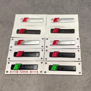May include: Multiple S line car emblems in silver, black, and green, each with a red or green 'S' logo. The emblems are rectangular, measuring 72mm in length, and are displayed on white backing cards.