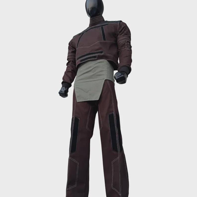 Puede incluir: Una parte superior de manga larga marr&oacute;n oscuro con cuello alto y detalles negros, combinada con pantalones marr&oacute;n oscuro a juego con paneles negros y costuras blancas en contraste. Un panel de tela verde oliva claro cubre la cintura.