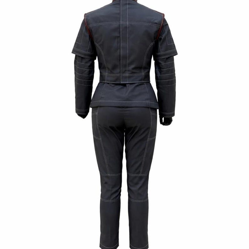 May include: A dark charcoal grey two-piece outfit consisting of a structured jacket and matching trousers. The jacket features a high collar, short sleeves with layered detailing, and a belted waist. Both pieces have prominent white topstitching.