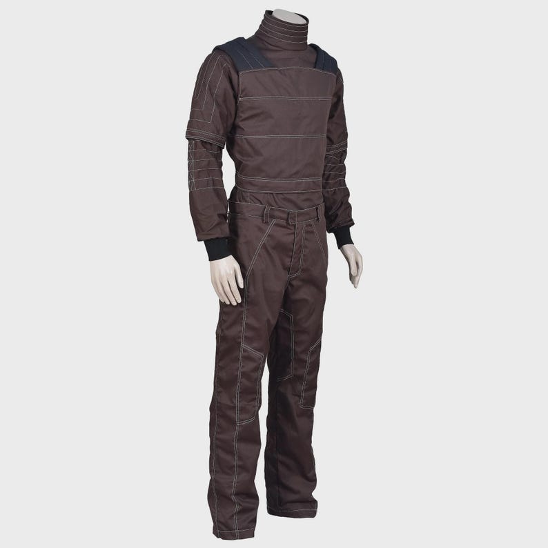 K&ouml;nnte beinhalten: Ein dunkelbrauner Langarm-Jumpsuit mit hohem Rippkragen, dunkelblauen Schulterpartien und wei&szlig;en Kontrastn&auml;hten. Das Kleidungsst&uuml;ck verf&uuml;gt &uuml;ber eng anliegende schwarze B&uuml;ndchen an den &Auml;rmeln und ein strukturiertes Design mit verst&auml;rkten Eins&auml;tzen.