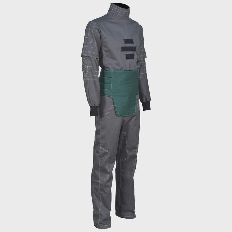 May include: A charcoal gray jumpsuit featuring a high collar, long sleeves with black cuffs, and white geometric stitching patterns. The garment includes a solid dark green rectangular panel across the waist and three horizontal black rectangular patches.