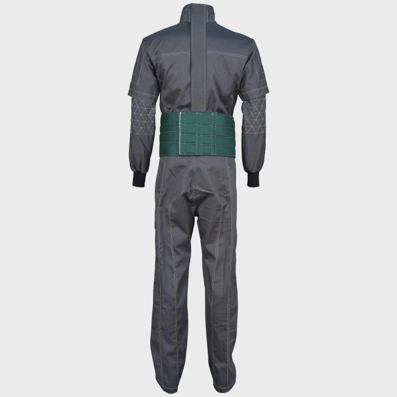 May include: A dark gray jumpsuit featuring long sleeves with white geometric stitching patterns on the forearms, a central vertical seam, and a wide, solid dark green belt secured around the waist. The garment has a structured collar and straight legs.