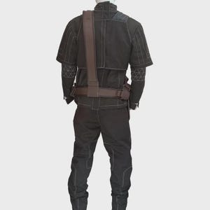 May include: A black long-sleeved jacket and matching trousers set featuring prominent white contrast stitching throughout. The jacket includes a high collar and a brown utility belt with a shoulder strap worn over the torso, showcasing geometric patterns.