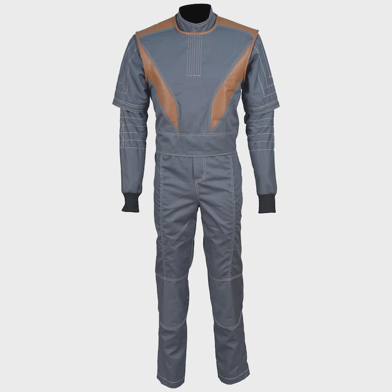 May include: A gray jumpsuit featuring a high collar, short sleeves, and brown panels on the chest and shoulders. The garment includes white topstitching details, a fitted waist, and black ribbed cuffs at the ends of the sleeves, creating a structured look.