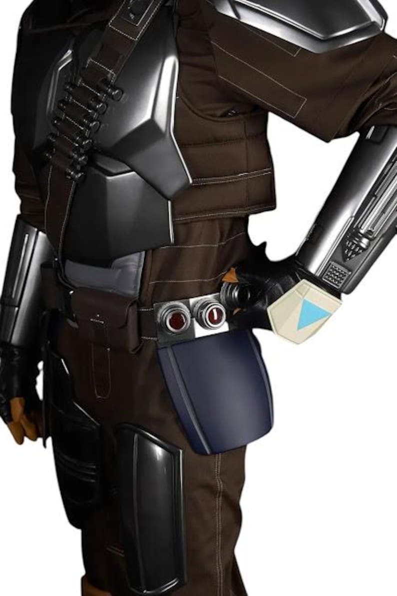 May include: A brown tactical jumpsuit featuring metallic silver chest and shoulder armor, black gauntlets with a light blue triangular accent, a utility belt with two circular red-centered buttons, and a dark blue thigh plate accessory.