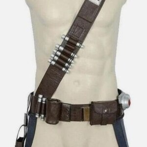 May include: A brown leather-like utility belt and shoulder strap set featuring a series of silver-toned cylindrical canisters attached to the diagonal strap and waist belt, along with a small rectangular pouch and a holster-style attachment.