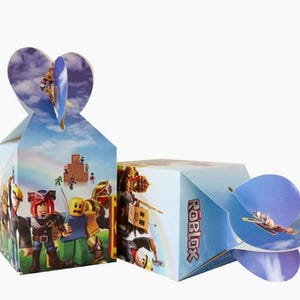 Puede incluir: Dos cajas de regalo rectangulares de cart&oacute;n con gr&aacute;ficos de personajes de Roblox y el logotipo de Roblox. Las cajas tienen un fondo de cielo azul claro con nubes y un arco&iacute;ris. La parte superior tiene solapas entrelazadas en forma de coraz&oacute;n.