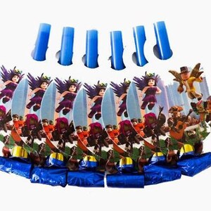 Puede incluir: Un conjunto de matracas de fiesta con recortes de cart&oacute;n circulares que muestran gr&aacute;ficos de personajes estilo bloque con trajes morados y dorados. Cada matraca tiene una boquilla de papel aluminio azul met&aacute;lico y un tubo de pl&aacute;stico azul.