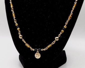 Colar de contas douradas com o signo de Capricórnio