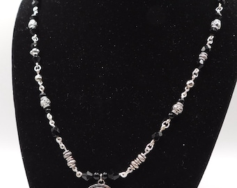 Colar de contas prateadas com o signo de Capricórnio