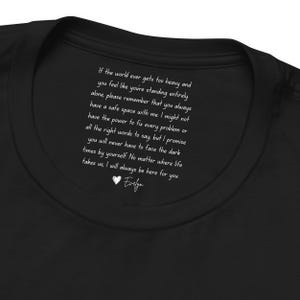 May include: Black t-shirt with white text. The text reads: "If the world ever gets too heavy and you feel like you're standing entirely alone... I will always be here for you. Evelyn."