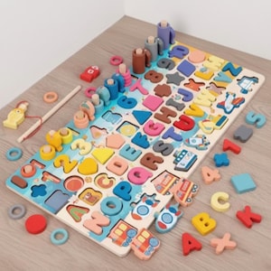 May include: Wooden educational toy featuring a colorful alphabet puzzle with matching letter pieces, numbers, and shapes. Includes a fishing game with wooden fish and a fishing rod. The puzzle is designed for early learning.