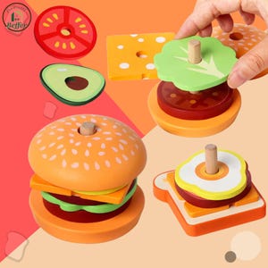以下が含まれることがあります： ハンバーガー、トマト、アボカド、チーズ、レタス、卵サンドイッチがセットになった木製おもちゃの食べ物セット。パーツは明るい色で、積み重ねられるように設計されています。ハンバーガーのバンズはオレンジ色で、白いゴマのディテールがあります。