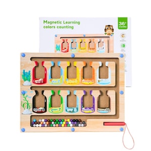 May include: Wooden magnetic learning toy with colorful bottles labeled with numbers and colors. The toy includes a wooden board with a maze, colorful beads, and the text "Magnetic Learning colors counting". The toy is designed for children aged 36 months and up.