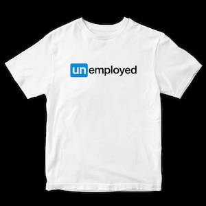 May include: White t-shirt with the word "unemployed" printed on the front. The letters "un" are in a blue box, and the word "employed" is in black. The shirt is made of a soft material.