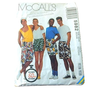 May include: A McCall's 5982 sewing pattern envelope for shorts in size medium. The front displays four individuals wearing various shorts with graphic prints, including soda cans, baseballs, and fish, paired with solid-colored tank tops and t-shirts.