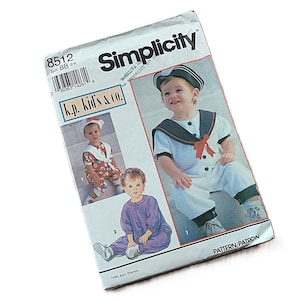 May include: Simplicity sewing pattern for children's clothing. The pattern features a sailor-themed outfit with a navy collar and a red bow. The package includes images of the finished garments and the "k.p. kids & co." logo.