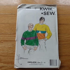 以下が含まれることがあります： Kwik Sewの型紙封筒1365。長袖シャツ2枚のイラストが描かれています。1枚は緑色で紫の横縞とボタン付き、もう1枚は黄色で青と白の幾何学模様のデザインです。紙製の封筒には文字が印刷されています。