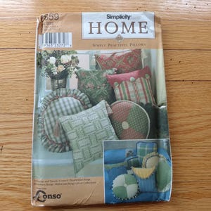 May include: A Simplicity Home sewing pattern envelope for pillows, numbered 8859. The front features illustrations of various decorative pillows in plaid, floral, and solid fabrics, including round and square shapes with tassels and trim details.