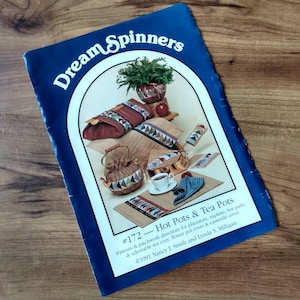 May include: A blue instructional booklet titled Dream Spinners #172 - Hot Pots & Tea Pots by Nancy J. Smith and Lynda S. Milligan. The cover features photographs of quilted kitchen items including a tea cosy, placemats, and a flower pot cover.