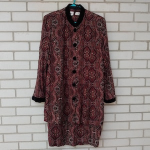 May include: A long-sleeved jacket featuring a dark red and black intricate paisley pattern. The jacket has a black stand-up collar, black cuffs, and a front button closure with five black buttons. The garment is displayed on a hanger.