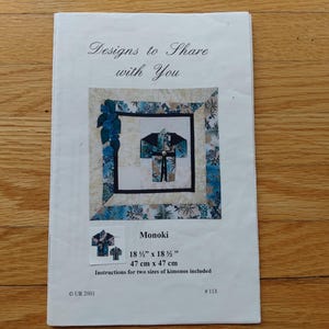 May include: A white instructional booklet titled Designs to Share with You featuring a quilt pattern with a blue and cream floral border and a central kimono graphic. The text includes Monoki, 18 1/2 inches by 18 1/2 inches, and 47 cm by 47 cm.