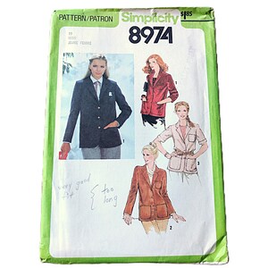 May include: A Simplicity 8974 sewing pattern envelope featuring illustrations of three blazer styles. The cover displays a dark blazer, a red blazer, and a light-coloured blazer with patch pockets. Handwritten notes on the front read very good fit and too long.