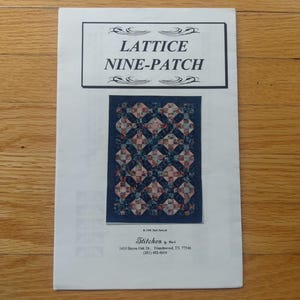 May include: A white paper featuring the title "LATTICE NINE-PATCH" within a black border. It displays a quilt pattern with a blue backdrop and a lattice design. The paper also includes the text "Stitches by Barb" and an address.