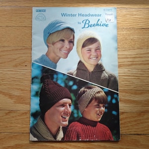 May include: Vintage magazine cover titled "Winter Headwear by Beehive." The cover shows four images of people wearing knitted winter hats and caps in different styles and colours. The background is a light blue with the Patons logo.