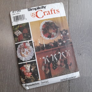 May include: A vintage Simplicity Crafts pattern featuring Christmas-themed crafts. The cover shows images of ornaments, a wreath, and stockings. The pattern includes instructions for creating festive holiday decorations.