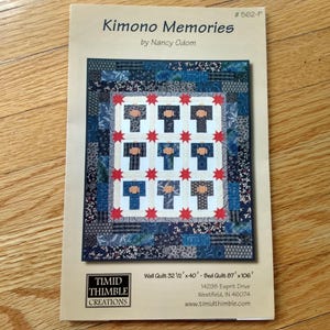 May include: A quilt pattern booklet titled Kimono Memories by Nancy Odom, featuring a quilt design with nine kimono-shaped blocks, red star accents, and a blue patterned border. The cover lists dimensions of 32.5 inches by 40 inches and 87 inches by 106 inches.