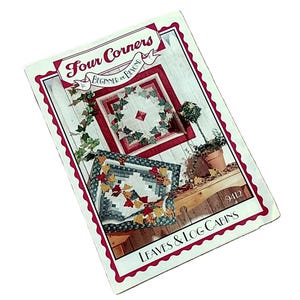 May include: A rectangular instructional booklet titled Four Corners Beginner and Beyond Leaves & Log Cabins, number 9412. The cover features two quilt designs with red, green, and white patterns, decorated with autumn leaf motifs.