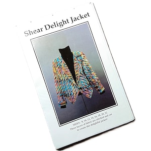 May include: A white booklet titled "Shear Delight Jacket" featuring a colourful jacket design. The jacket is displayed on a mannequin. The text on the booklet indicates sizes 8, 10, 12, 14, 16, 18, 20, and 22.