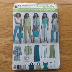 May include: A Simplicity sewing pattern for wardrobe elements. The pattern features illustrations of women wearing various outfits, including pantsuits, tops, and a long coat. The pattern includes sizes AA 10, 12, 14, 16, 18.